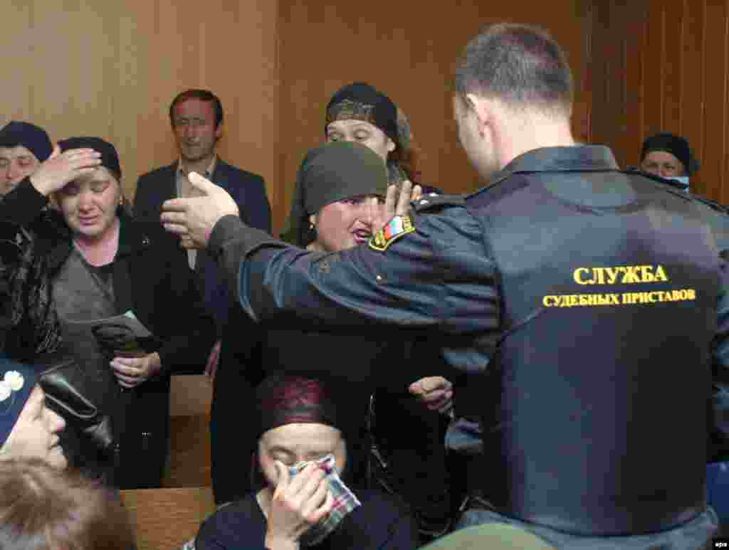 A bailiff tries to silence women speaking out during the trial of Nurpashi Kulayev, the only militant arrested during the Beslan hostage crisis, at a court in Vladikavkaz on May 19, 2005.