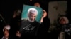 Saeed Jalili's supporters hold up one of his campaign posters ahead of Iran's presidential election on June 28. Jalili finished second among four candidates and will head to a run-off vote on July 5. 