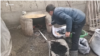 A man feeds coal into an outdoor oven in Uzbekistan. (file photo)
