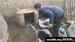 A man feeds coal into an outdoor oven in Uzbekistan. (file photo)
