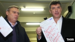 Opposition leaders Mikhail Kasyanov (left) and Boris Nemtsov show their defaced ballots during parliamentary elections at a polling station in Moscow in December 2011.