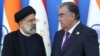 Tajik President Emomali Rahmon (right) and Iranian President Ebrahim Raisi speak while posing for a picture during the Shanghai Cooperation Organization summit in Dushanbe in 2021.