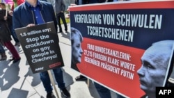 Activists display placards in front of the Chancellery in Berlin in April during a demonstration calling on Russian President Vladimir Putin to put an end to the persecution of gay men in Chechnya. The protesters called on German Chancellor Angela Merkel, who met with Putin in Sochi on May 2, to raise the issue. She said afterward that she had urged Putin to "use his influence" to end the abuse.