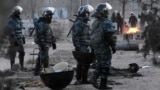 Riot police patrol the Kazakh town of Zhanaozen shortly after violence claimed the lives of at least 16 striking oil workers.