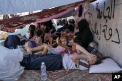 Children with their families lie on the ground in Beirut's Martyrs' Square after fleeing the Israeli air strikes in Beirut's southern suburbs on September 28.