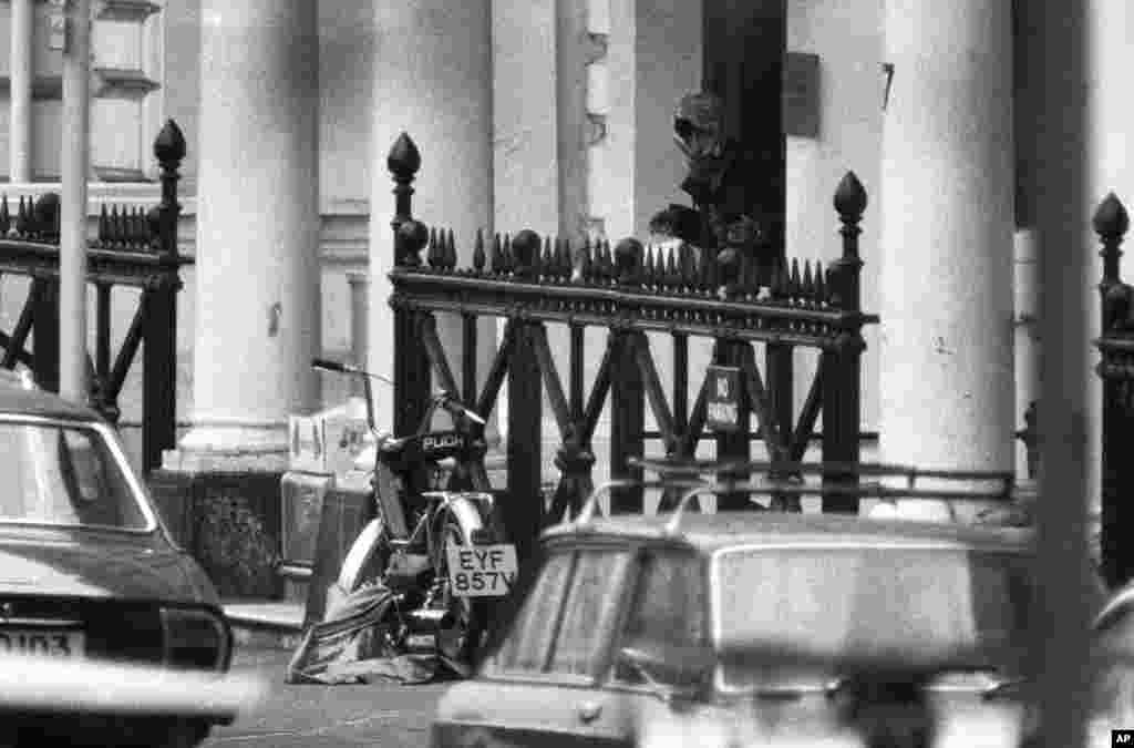 A hooded man appears at the door of the Iranian Embassy in London on May 2, 1980, with what appears to be a gun in his left hand. The hostage takers had their demands aired on the BBC. The broadcast was arranged after negotiations with police. The release of five hostages was secured in exchange.