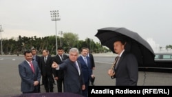 Azerbaijani Transport Minister Ziya Mammadov (foreground center) presenting London taxis in Baku to President Ilham Aliyev (right) in June 2011. Mammadov's ministry awarded the contract to import 1,000 of the taxis to the Baghlan Group, a major holding to which his son Anar Mammadov had financial links.