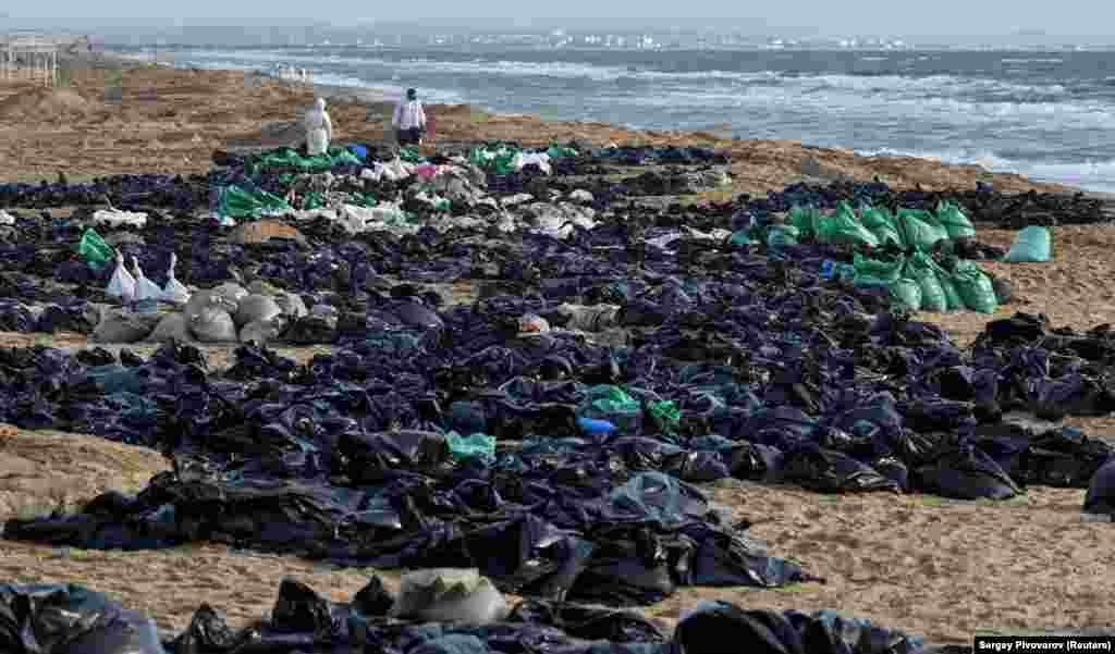 Volunteers work to clear an oil spill on the Black Sea coastline in Russia&#39;s Krasnodar region following an incident involving two tankers damaged in a storm in the Kerch Strait.&nbsp;