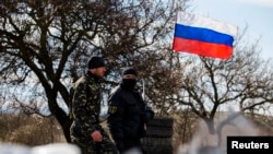 Members of a local "self-defense" unit man a checkpoint on the highway between Simferopol and Sevastopol in Crimea in March.