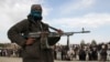 A Taliban militant and locals attend the execution of three men condemned by a shadow court in Ghazni Province. (file photo)