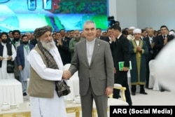 The Taliban's prime minister, Mullah Mohammad Hassan Akhund (left), and the head of the People's Council of Turkmenistan, Gurbanguly Berdymukhammedov, attend a ceremony to resume the construction of a major gas pipeline.