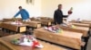 School workers place donated bouquets of flowers on the empty desks of students killed in a May 8 attack on the Sayed al-Shuhada school in Kabul's Hazara district. 