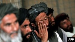 Afghans discuss security at a local council meeting in Helmand Province in June 2010.