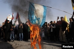 Iranians burn a painted Israeli flag during a gathering in Tehran to support Iran's October 1 attack on Israel.