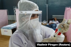 A medical specialist treats patients at a hospital in Bishkek in July.