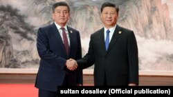 Then-Kyrgyz President Sooronbai Jeenbekov (left) and Chinese President Xi Jinping met on the sidelines of the Shanghai Cooperation Organization summit in Qingdao in June 2018.