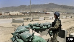 An Afghan soldier stands guard at the gate of an air-force compound in Kabul in April 2011.