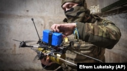 A Ukrainian soldier of the 71st Jaeger Brigade prepares an FPV drone at the front line near Avdyivka, Donetsk region.