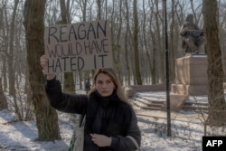 A young woman holds a placard during a protest against the proposed U.S.-Ukraine minerals deal with the United States near the American Embassy in Kyiv this week.