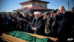 Members of the Crimean Tatar community pray over the coffin of Reshat Ametov during his funeral in Simferopol on March 18. His body bore the marks of a violent death, according to Human Rights Watch.