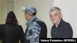 Yury Dmitriyev is escorted to court in Petrozavodsk.