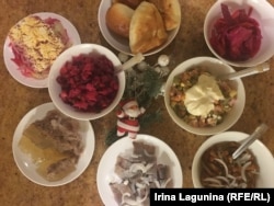 Irina Lagunina's New Year's table: Top row (left to right): seledka pod shuboi (a salad of pickled herring "in a fur coat"), pirozhki pastries (often stuffed with meat, mushrooms, cabbage, and even jam), and pickled cabbage. Center: vinegret (Russian beetroot salad) and Salad Olivier (Russian salad). Bottom row: kholodets, seledka (pickled herring with marinated onion), and salted mushrooms.