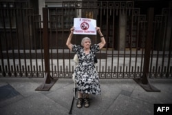 Lyudmila Alekseyeva holds a poster reading "I oppose sadists' law" as she pickets against Russia's NGO law in front of the State Duma in Moscow in May 2015.