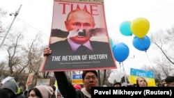 A demonstrator holds a placard at a protest against Russia's war on Ukraine in Almaty, Kazakhstan.