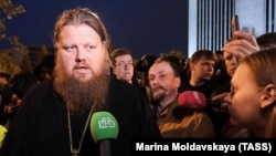 Father Maksim Menyailo talks to protesters on May 16.