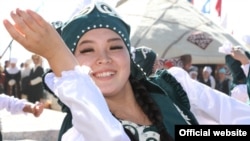 A Kyrgyz women wears traditional clothing.