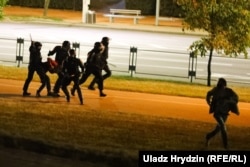 Riot police beat a group of people while another attempts to flee on August 11-12.