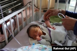 A newborn baby is cared for at the Ataturk Children's Hospital a day after being rescued from a deadly attack on another maternity hospital, in Kabul on May 13, 2020.