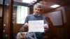 Aleksei Gorinov inside a glass cell during a hearing in his trial at a courthouse in Moscow in June 2022.