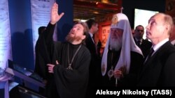 Archimandrite Tikhon (left), who has been described as Putin's spiritual mentor, took the exhibition under his wing.