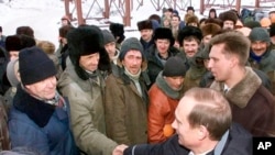 Putin shakes hands with workers during a visit to an oil and gas field in Surgut, Siberia, in March 2000.