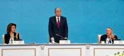 Qasym-Zhomart Toqaev (center) stands as Nursultan Nazarbaev (right) and Darigha Nazarbaeva applaud him at the Nur Otan party congress in Nur-Sultan on April 23.