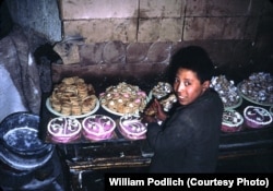 A boy decorates cakes, cookies, and other sweets.