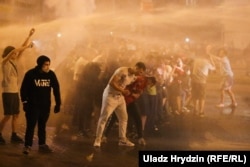 Police try to disperse protesters with a water cannon on August 9-10.