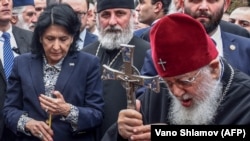 Georgian President Salome Zurabishvili (left) and Georgian Orthodox Patriarch Ilia II take part in a prayer during a commemoration ceremony in Tbilisi.