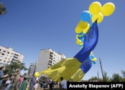 Avdiyivka residents launch balloons with a giant Ukrainian flag during Independence Day celebrations in August 2018.