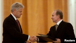 Clinton and Russian President Vladimir Putin exchange signed agreements on the establishment of a joint warning center for the exchange of information on missile launches on June 4, 2000.