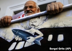 A demonstrator holds a placard depicting Vladimir Putin during an opposition rally in Minsk in 2015.