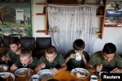 Children from a military-patriotic club eat together in the village of Sengileyevskoye in Russia's Stavropol region. (file photo)