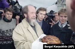 Solzhenitsyn receives a traditional Slavic greeting of bread and salt upon his arrival in Vladivostok after returning to Russia following an absence of two decades.