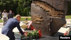 Russian President Vladimir Putin lays flowers at the monument to the sailors who died in the disaster in the city of Kursk in August 2003.