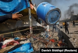 People supporting changes to the citizenship law destroy the protest site used by those opposing them in New Delhi in February 2020.