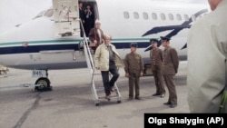 Aleksandr Solzhenitsyn, followed by his wife, Natalia, steps off a plane in Vladivostok and sets foot on Russian soil for the first time in 20 years in May 1994. 