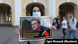 A woman in St. Petersburg holds up a poster in support of Aleksei Navalny, a popular Russian opposition leader whose poisoning on August 20 could leave him incapacitated for months. 