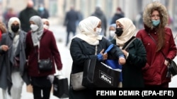 Women wearing face masks walk on the street in Sarajevo last month. By December 11, there were 99,543 confirmed infections and 3,250 COVID-19 deaths in the country of 3.4 million..