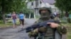 Women walk toward a Ukrainian government soldier searching for members of Right Sector in the village of Bobovyshche, near Mukacheve, on July 13.